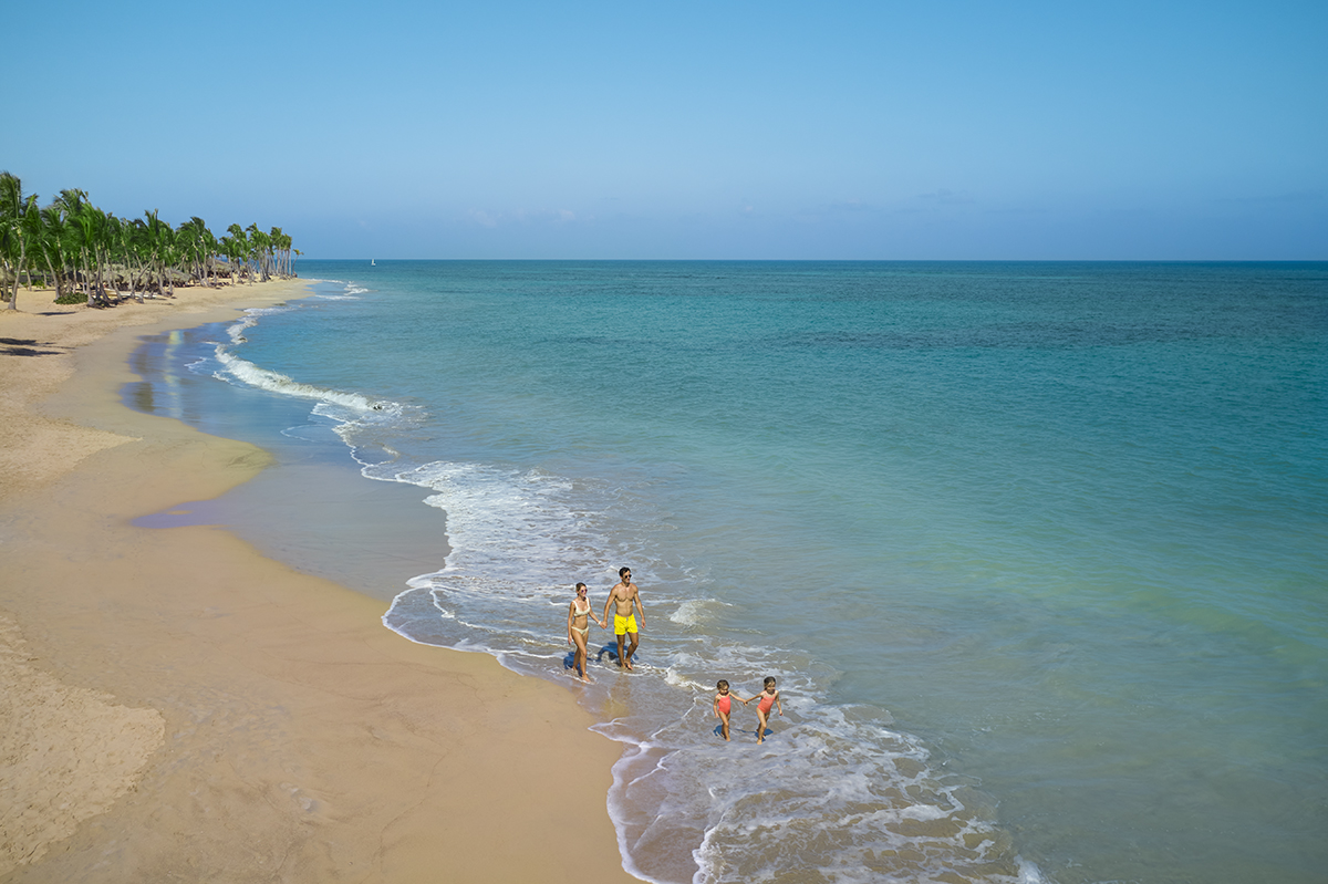 Family walking alongside the ocean at a beach in the Dominican Republic