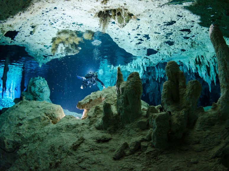 Scuba diver exploring the underwater caves of the Dos Ojos cenote in Mexico