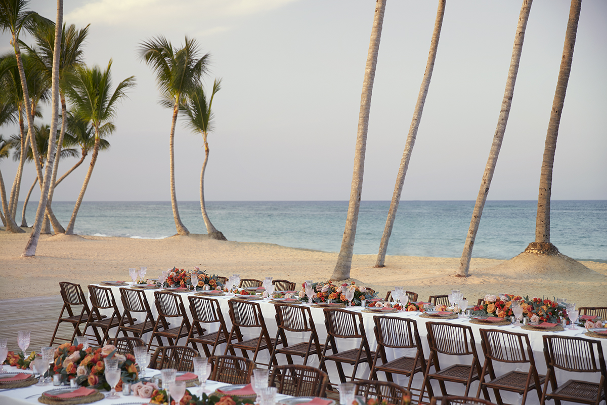 Long table by the beach with seating arrangements so that everyone can sit together
