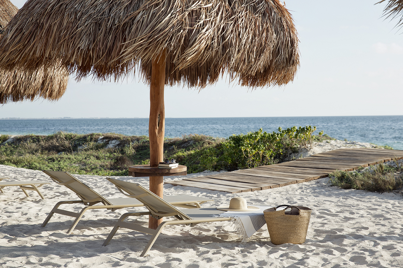 A tropical beachfront setting with an empty tanning bed